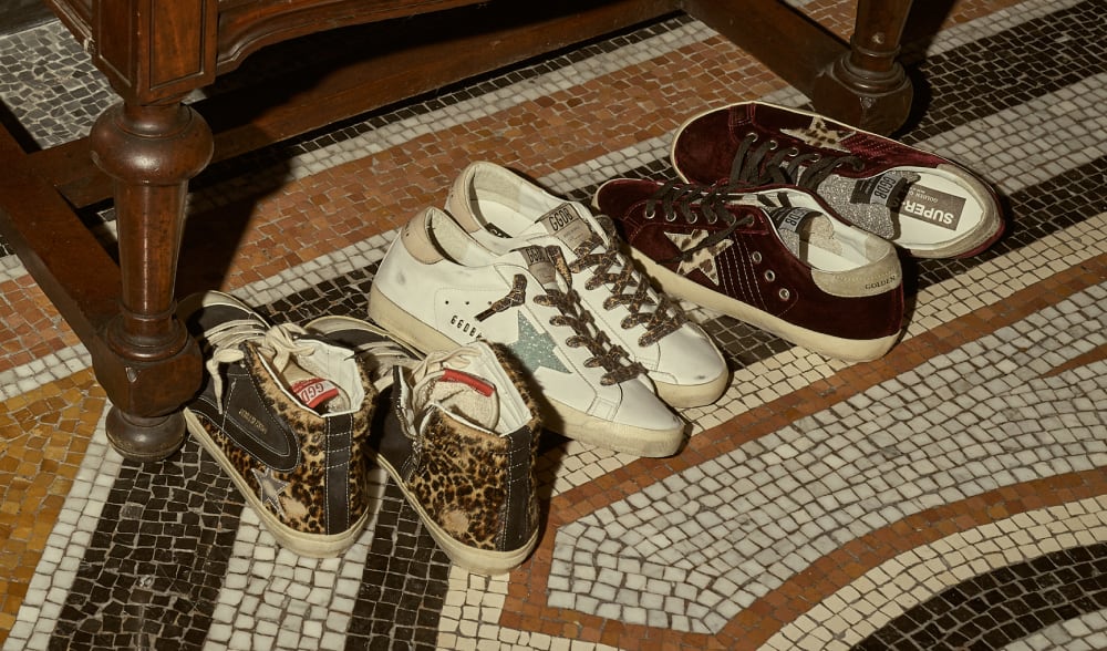 three-pair-of-animalier-printed-sneakers-on-colored-marble-tiled-floor