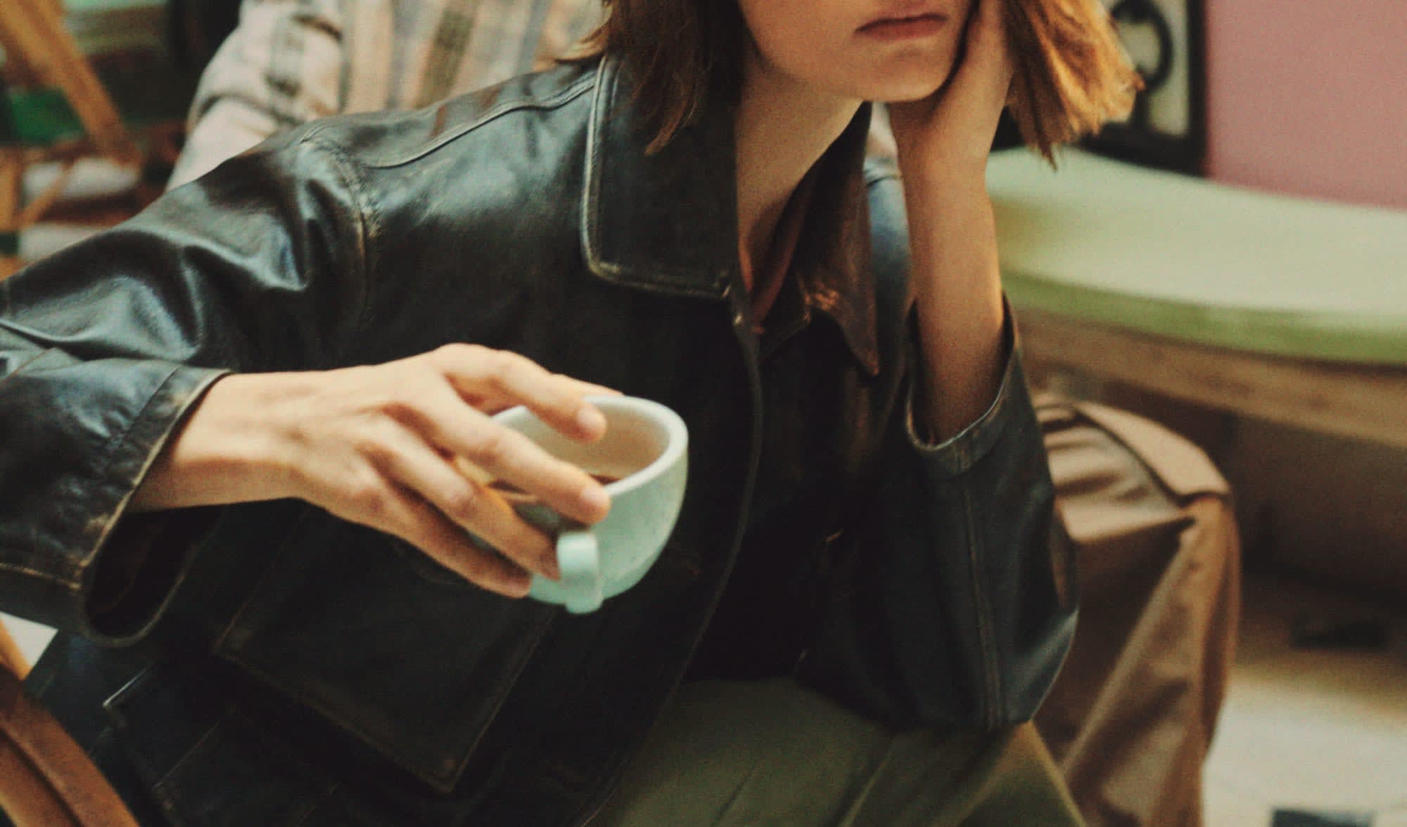 woman-with-leather-jacket-holding-white-coffee-cup