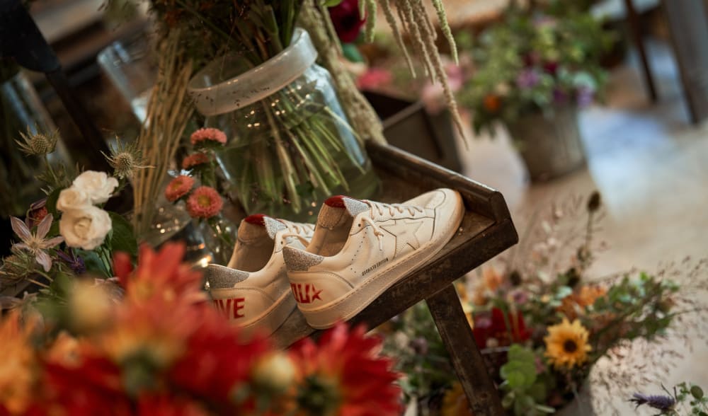 White-ball-star-sneakers-on-wooden-table-in-flower-shop