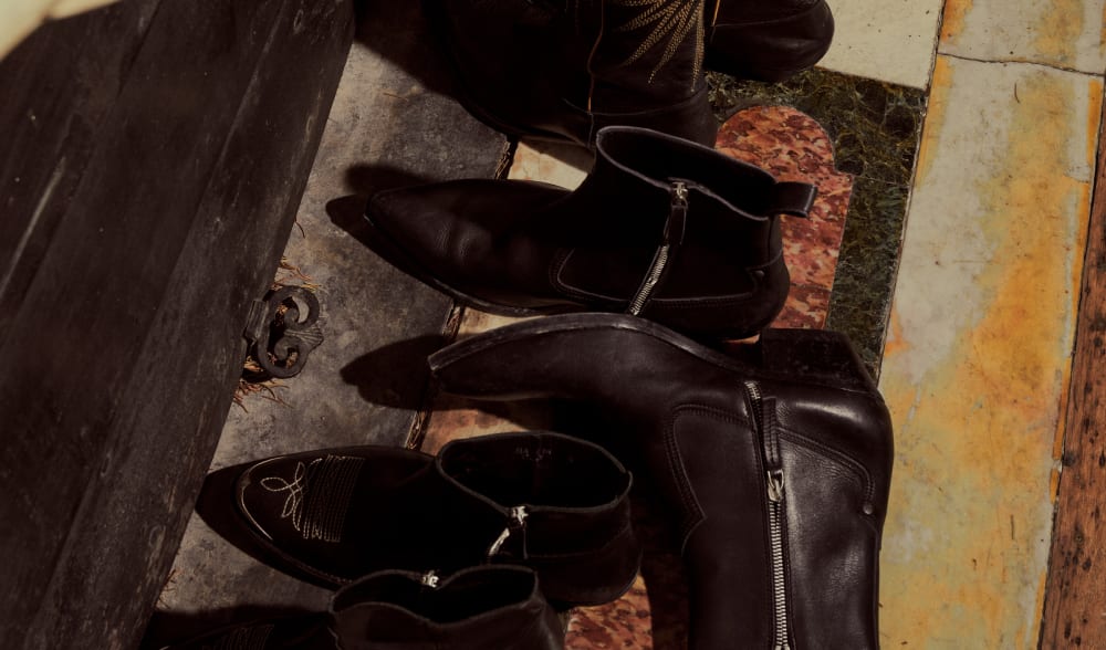 top-view-of-a-groupage-of-black-boots-in-front-of-a-fireplace