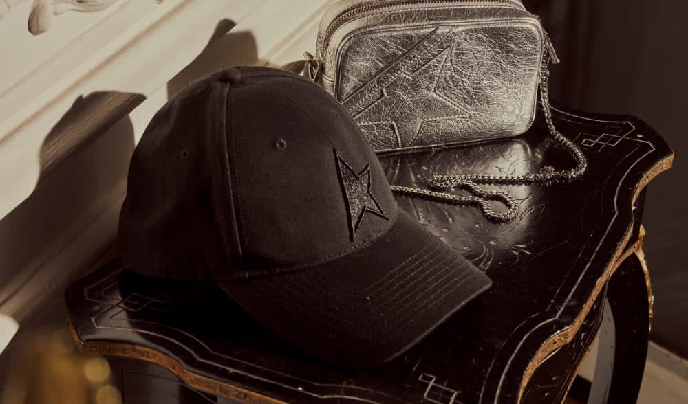 Black-baseball-cap-with-star-on-an-ancient-table-close-to-a-silver-handbag
