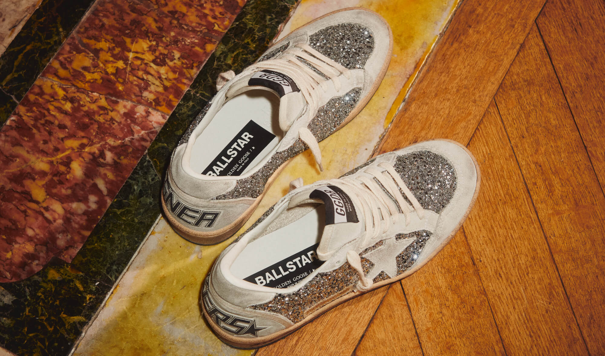 top-view-of-silver-glittered-ball-star-sneaker-on-wooden-floor