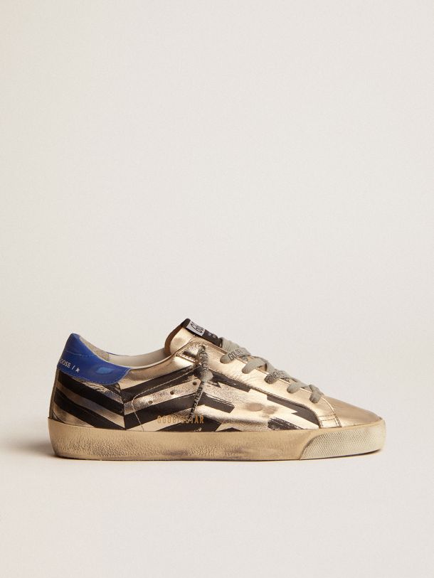 Golden Goose - Super-Star sneakers in platinum-colored laminated leather with black flag print and red and blue heel tab in 