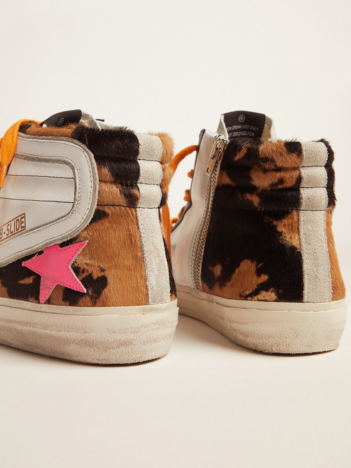 Slide sneakers in pony skin with orange laces and a fuchsia star