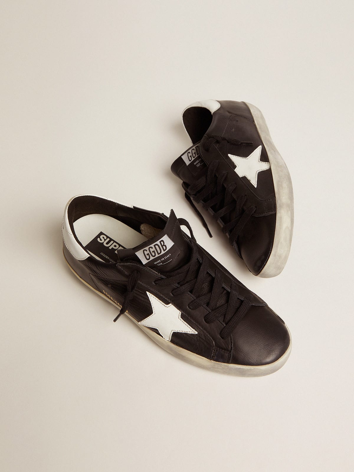 Golden goose white hot sale and black superstar sneakers