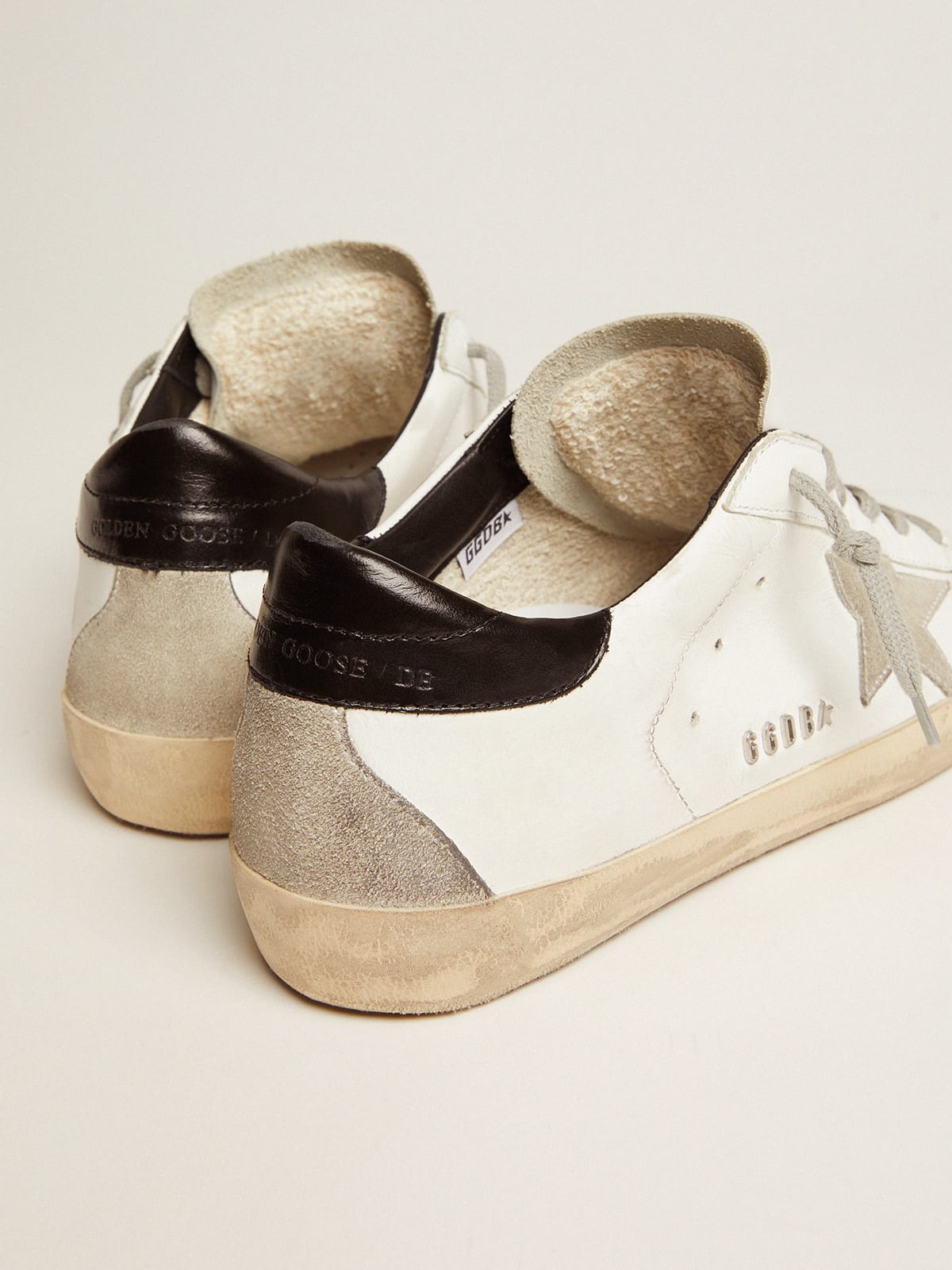 Golden goose superstar sneakers with gold store star and glitter black heel tab