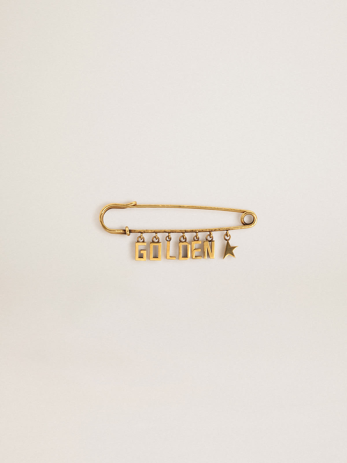 Golden Goose - Pin in old gold color with drop Golden lettering in 